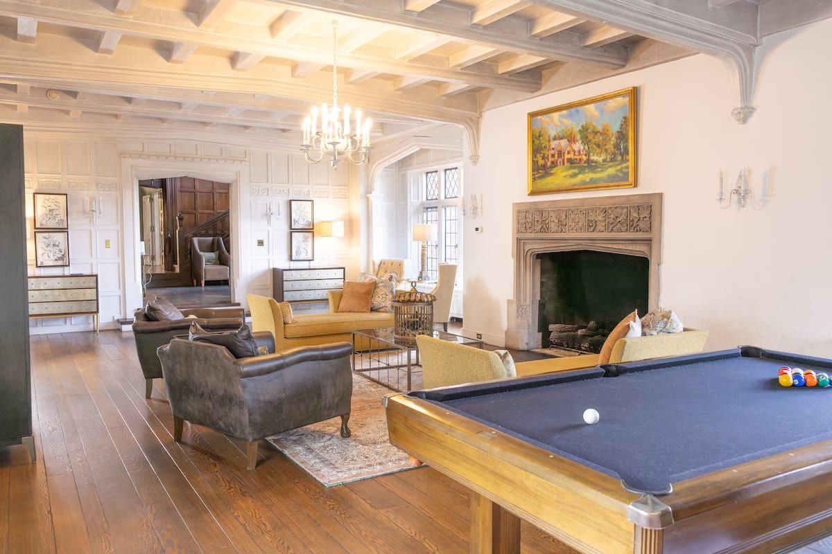 Great room with billiards table and carved stone fireplace