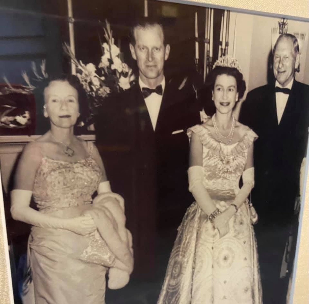 Vintage black-and-white photo of four formally dressed people at an elegant event
