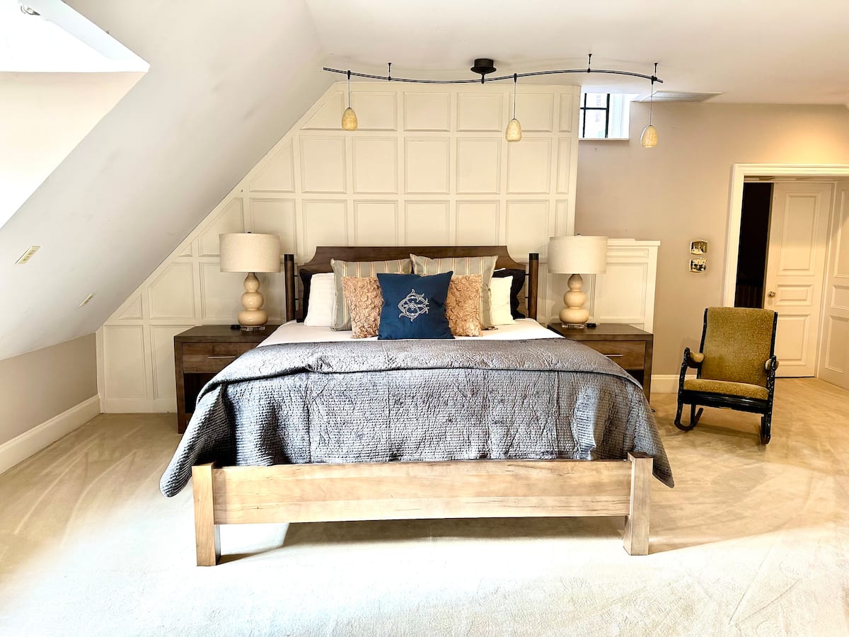Attic bedroom with king bed and paneled accent wall