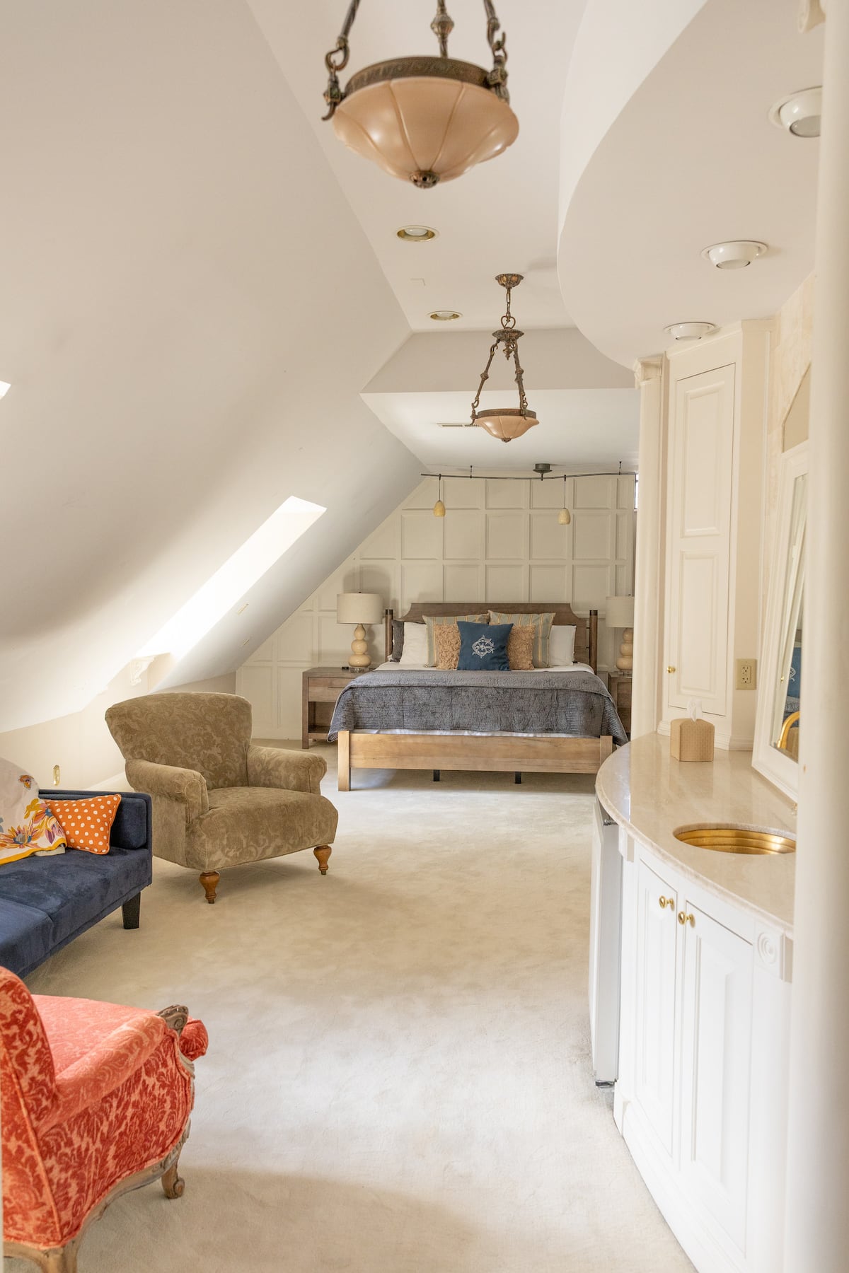 Attic bedroom with vaulted ceilings, skylight, and seating area