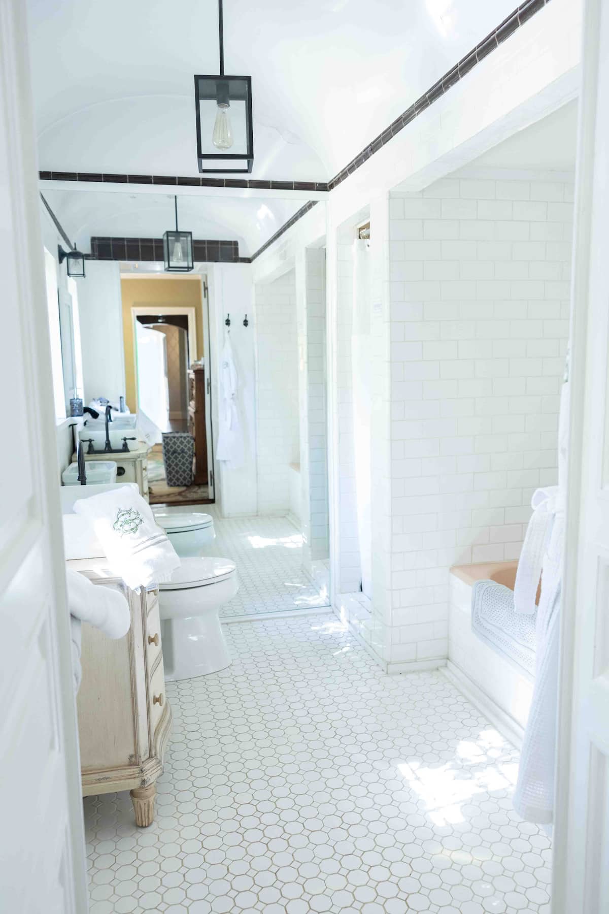 White farmhouse bathroom with subway tile and hexagon floors