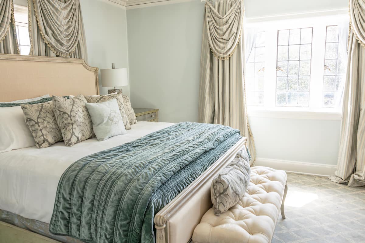 Luxurious bedroom with teal bedding and elegant drapes