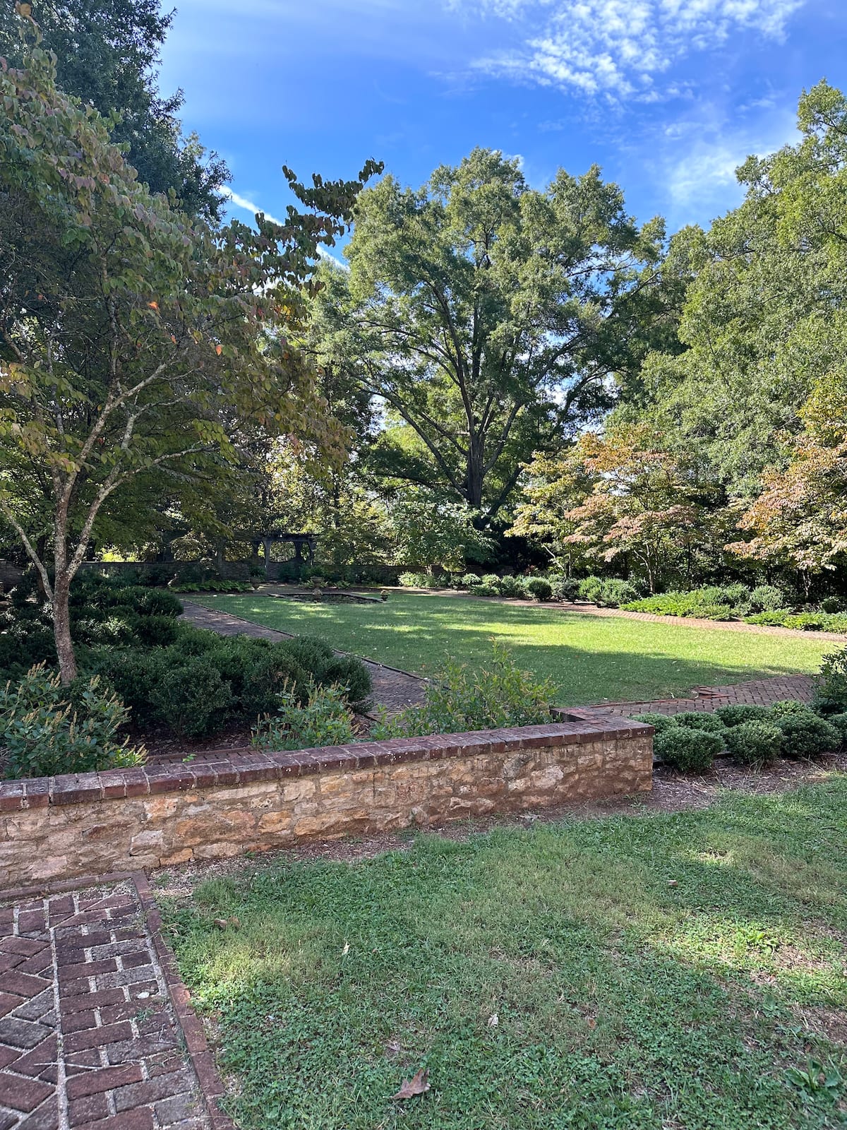 Terraced estate lawn with brick paths and mature trees