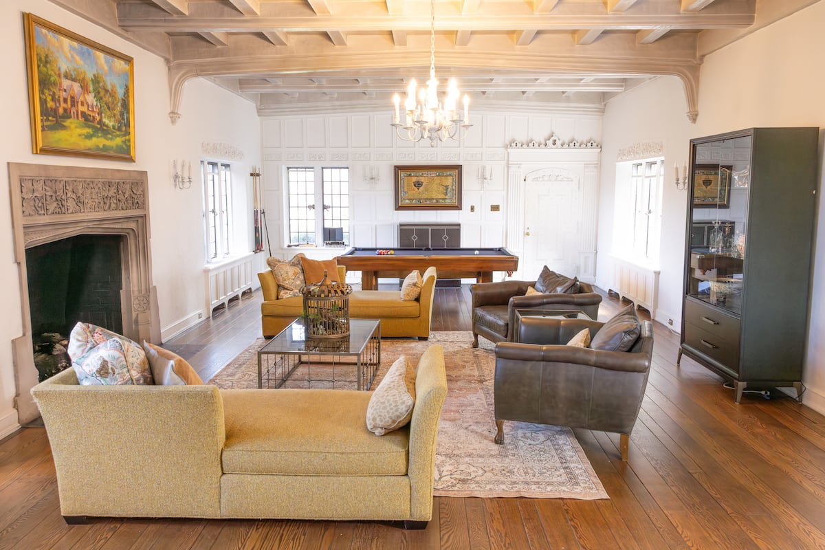 Wide view of billiards room with fireplace and seating