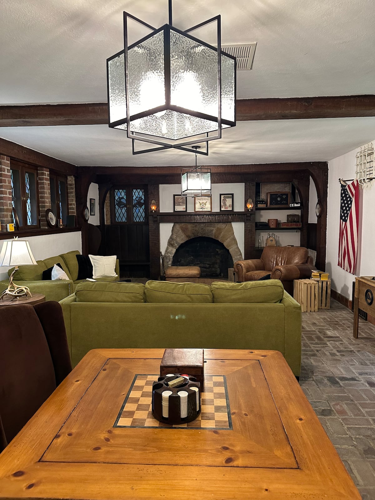 Rustic Tudor living room with stone fireplace and game table