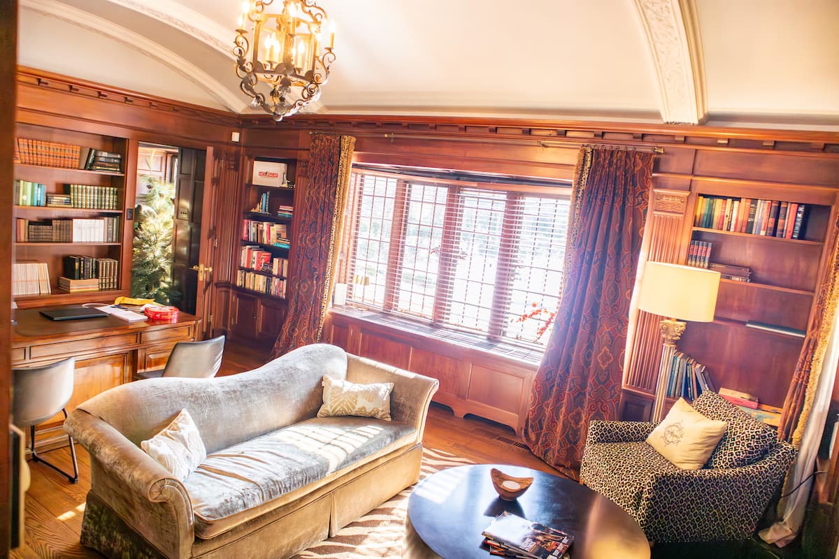 Wood-paneled library study with bookshelves and vaulted ceiling
